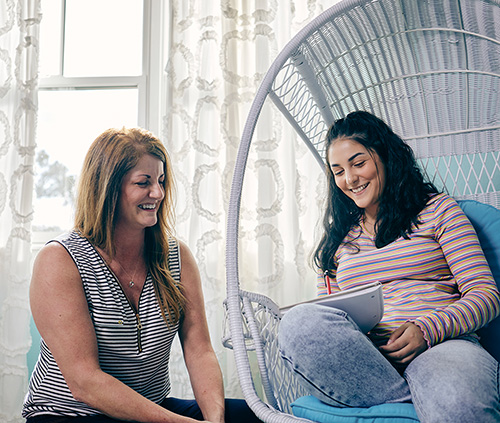 girl and mom smiling and writing in the notebook